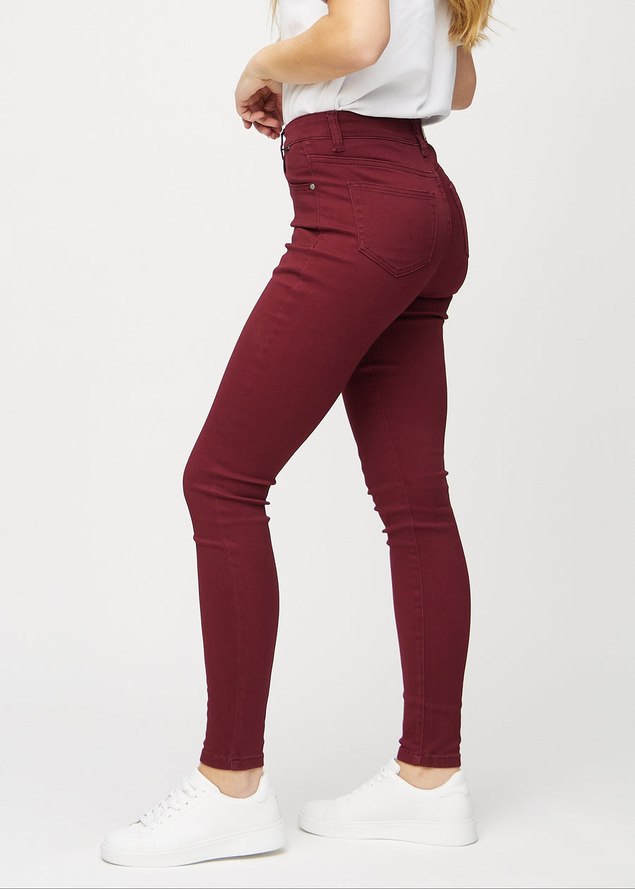 Dunkelrote skinny jeans an einem Model von der Seite gesehen.