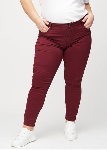 Dunkelrote skinny jeans, Modellname Santas, die an einem Plus-Size-Model eng am Bein anliegen, von vorne gesehen.