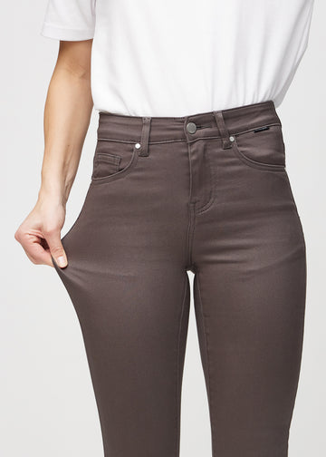 Skinny-Jeans für Damen in Graubraun, Farbe Thunders. Ein Model dehnt den Jeansstoff am Oberschenkel, um den Stretch zu zeigen.