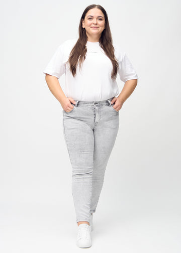 Ganzkörperbild eines Plus-Size-Models in hellgrauem Denim slim jeans.