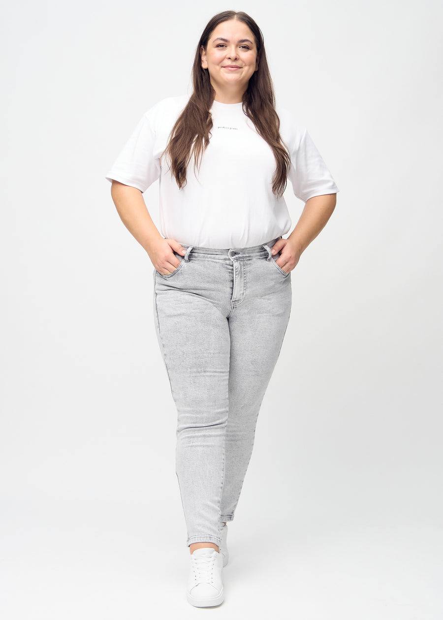 Ganzkörperbild eines Plus-Size-Models in hellgrauem Denim slim jeans.