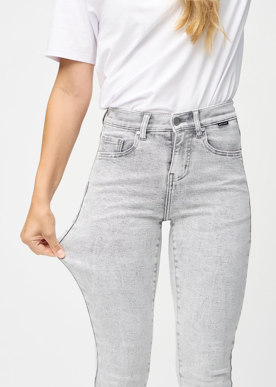 Das Model zieht die Jeans am Oberschenkel auseinander, um den Stretch zu zeigen.