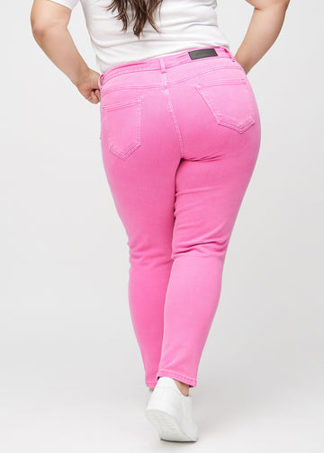 Hellrosa slim jeans von hinten an einem Plus-Size-Model gezeigt, damit man das gesamte Produkt sehen kann.