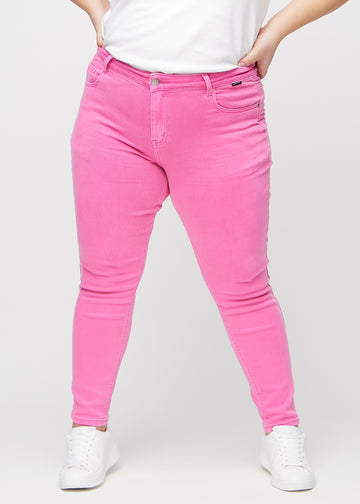 Hellrosa slim jeans, Modellname Flamingos, die eng am Bein sitzt, jedoch am Knöchel etwas lockerer, an einem Plus-Size-Model, von vorne gesehen.
