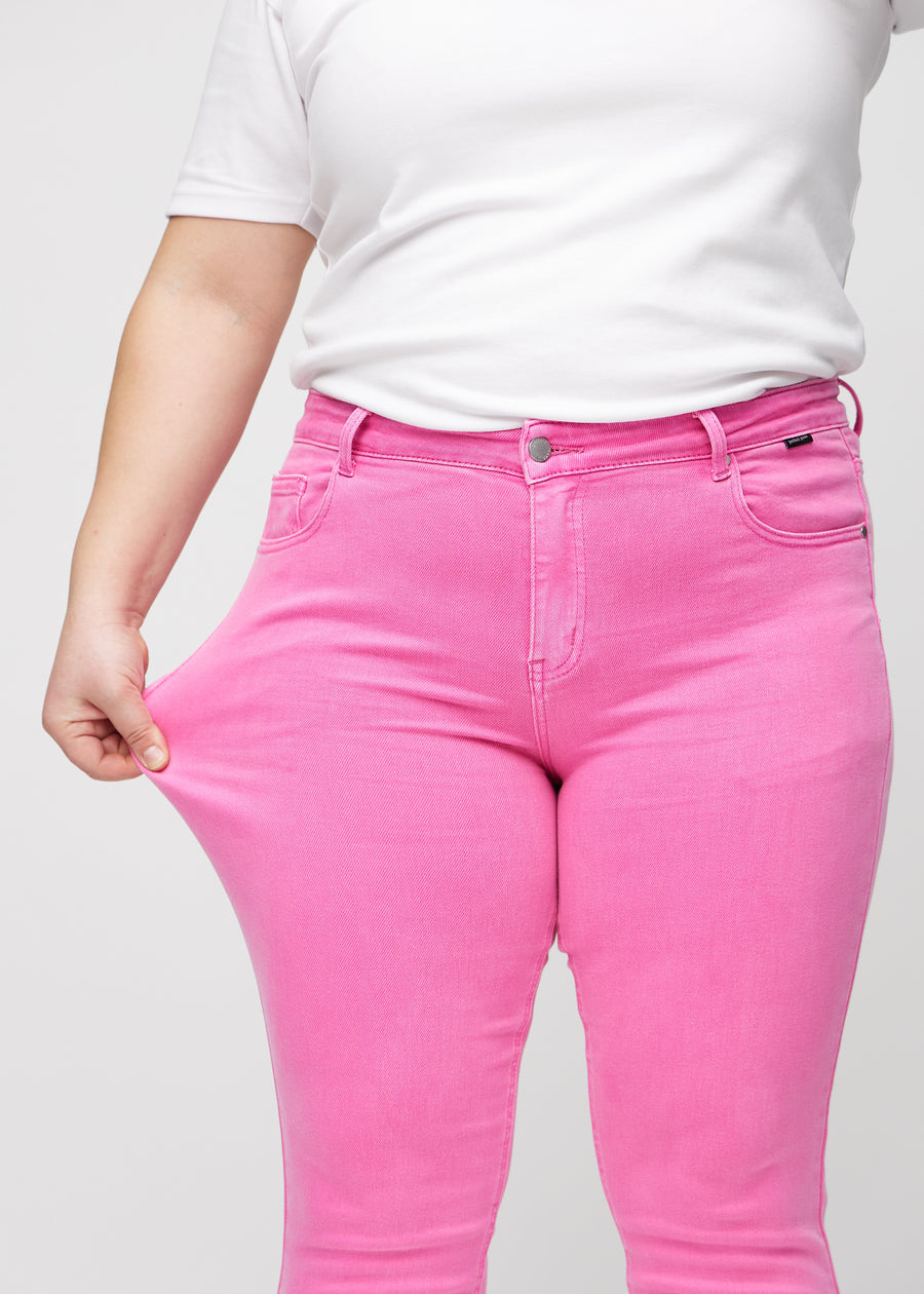 Das Plus-Size-Model zieht die Jeans am Oberschenkel auseinander, um den Stretch zu zeigen.