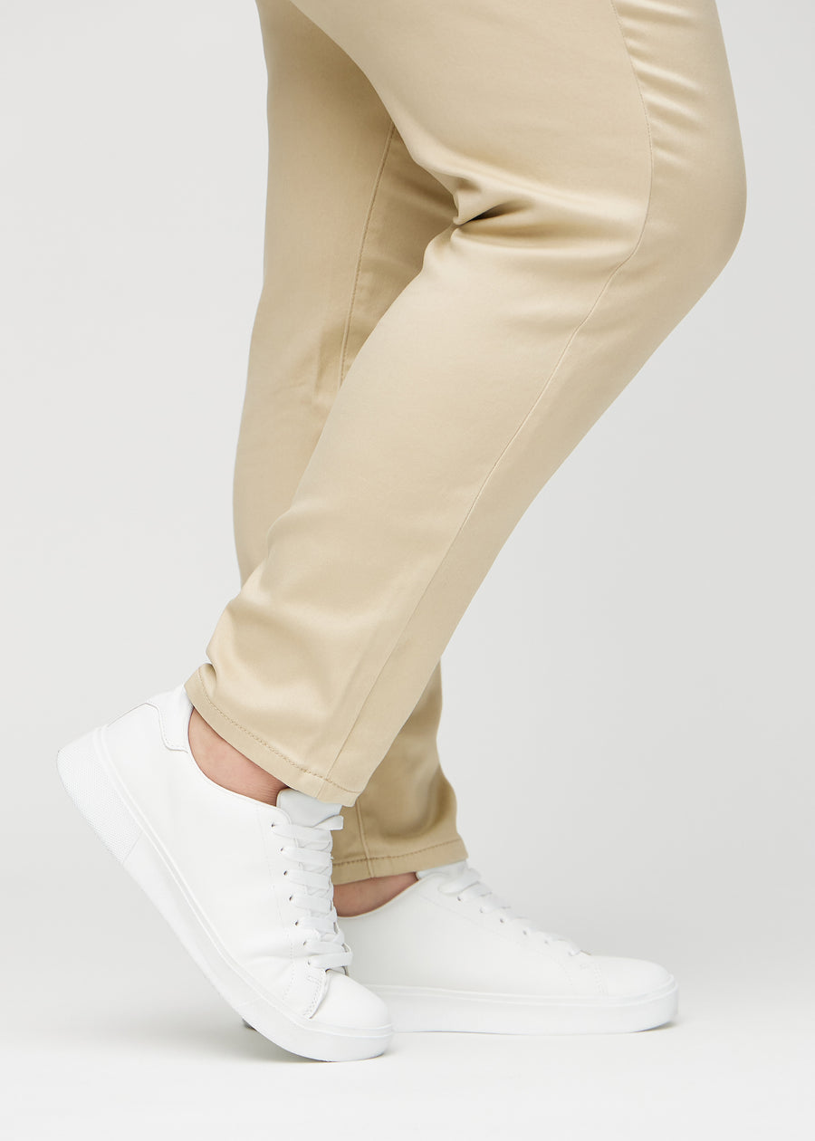 Slim-Jeans für Damen in Beige, Farbe Gazelles. Nahaufnahme an den Knöcheln eines Plus-Size-Models, um die Passform am Beinabschluss zu zeigen.