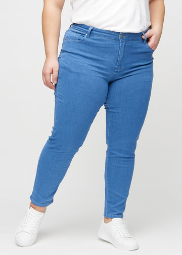Slim-Jeans für Damen in Blau, Farbe Geraniums. Vorderansicht an einem Plus-Size-Model, körpernah geschnitten mit etwas mehr Platz am Knöchel.