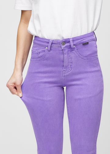 Slim-Jeans für Damen in Lila, Farbe Lavenders. Ein Model zieht am Jeansstoff am Oberschenkel, um den Stretch zu zeigen.
