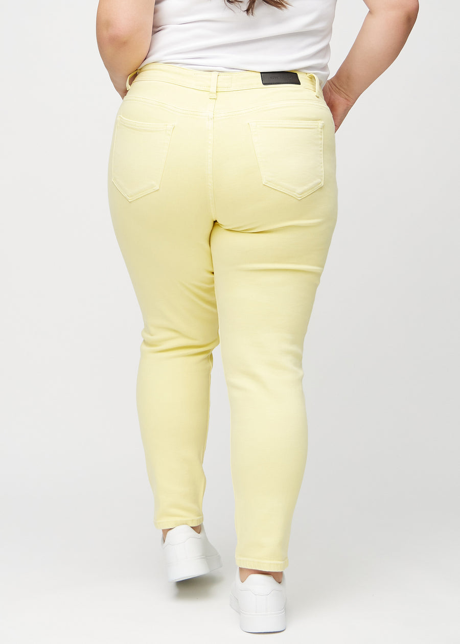 Hellgelbe slim jeans von hinten an einem Plus-Size-Model gesehen, damit man das gesamte Produkt sehen kann.