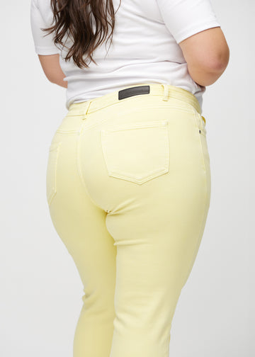 Hellgelbe slim jeans von hinten aus der Nähe an einem Plus-Size-Model gesehen, um Details zu zeigen.