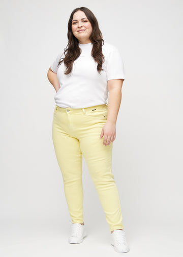 Ganzkörperbild eines Plus-Size-Models in hellgelben slim jeans.