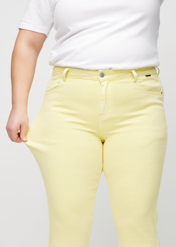 Das Plus-Size-Model zieht die Jeans am Oberschenkel auseinander, um den Stretch zu zeigen.