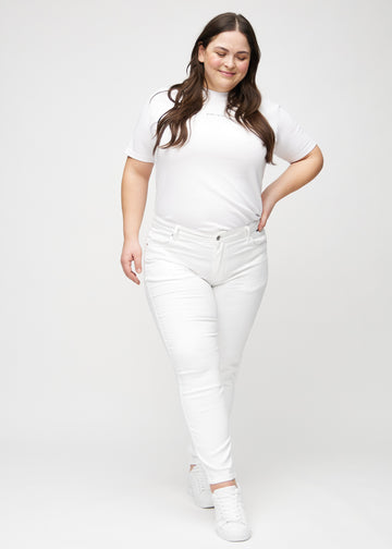 Ganzkörperbild eines Plus-Size-Models in weißen slim jeans.