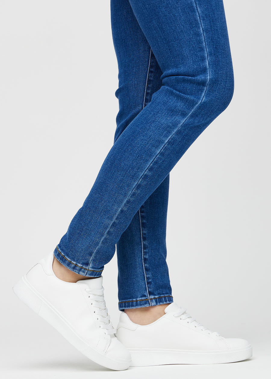 Slim-Jeans für Damen in Dunkelblau, Farbe Oceans. Nahaufnahme an den Knöcheln eines Models, um die Passform am Beinabschluss zu zeigen.