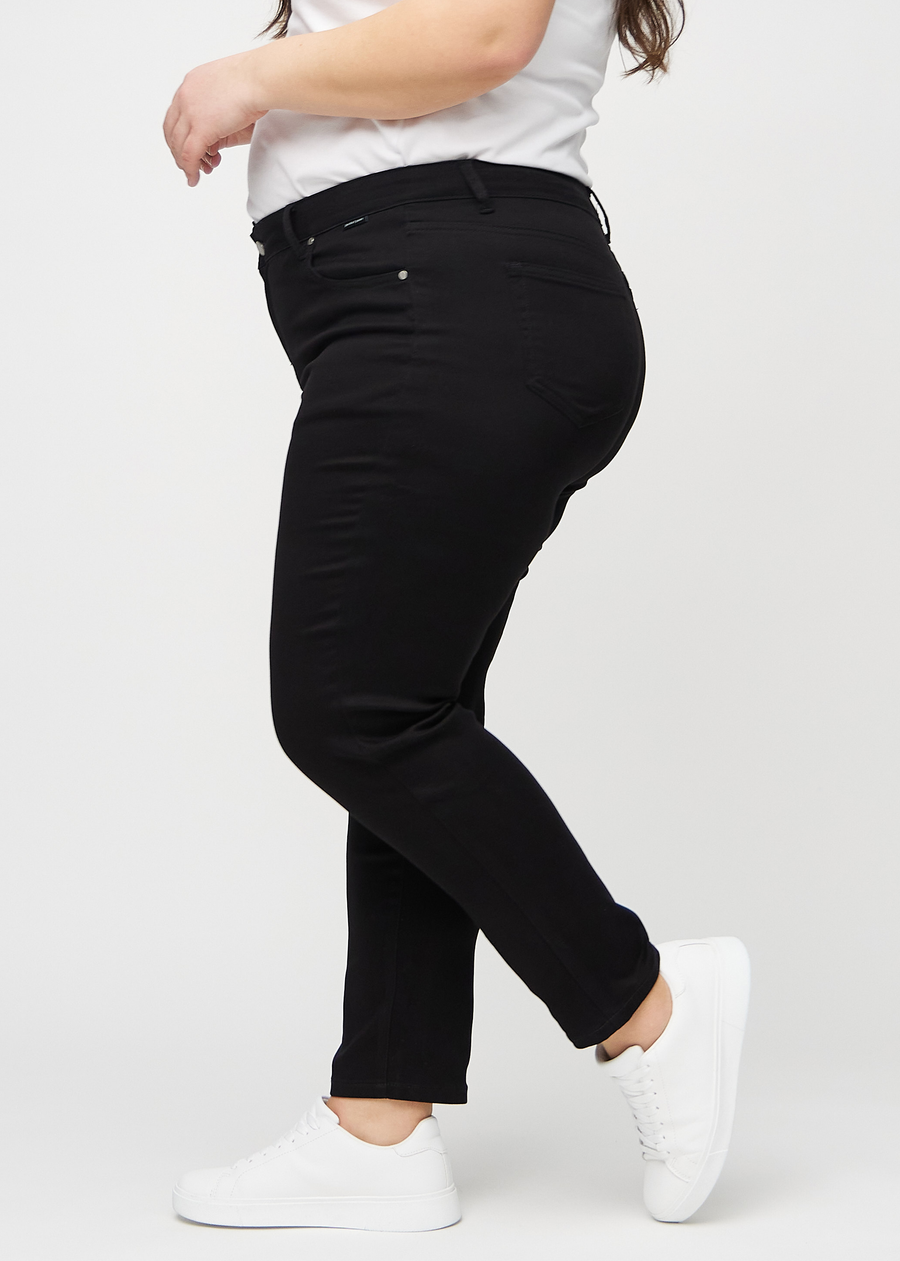 Schwarze slim jeans von der Seite an einem Plus-Size-Model gesehen.