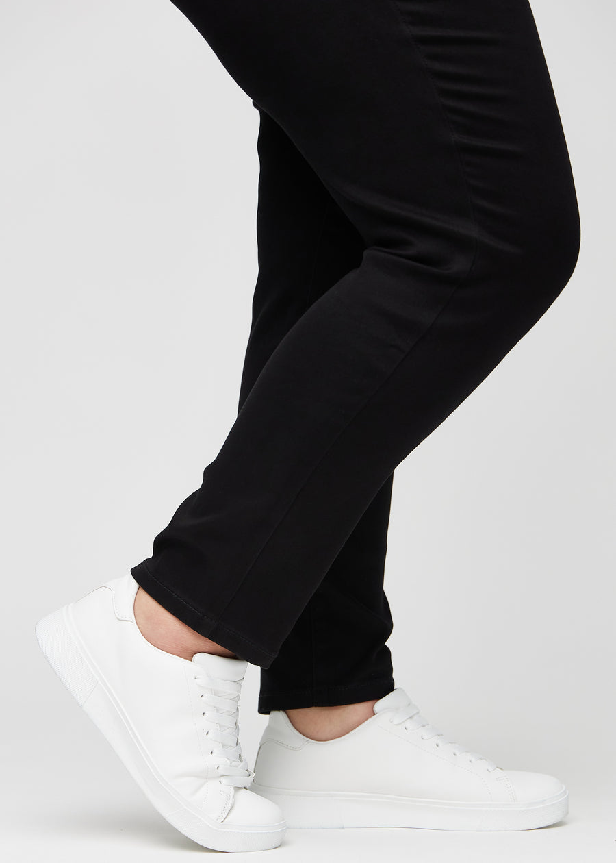 Die Knöchel eines Plus-Size-Models, sodass man sehen kann, wie eng die Jeans in einer Slim Passform anliegen.