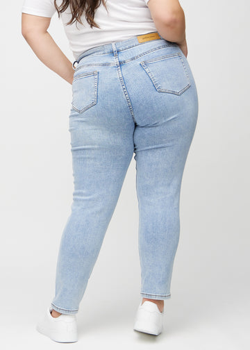 Heller Denim slim jeans von hinten an einem Plus-Size-Model gesehen, sodass man das gesamte Produkt sehen kann.