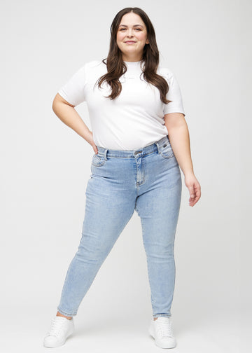 Ganzkörperbild eines Plus-Size-Models in hellem Denim slim jeans.