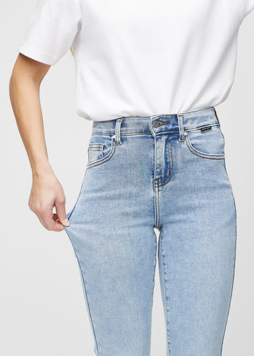 Das Model zieht die Jeans am Oberschenkel auseinander, um den Stretch zu zeigen.