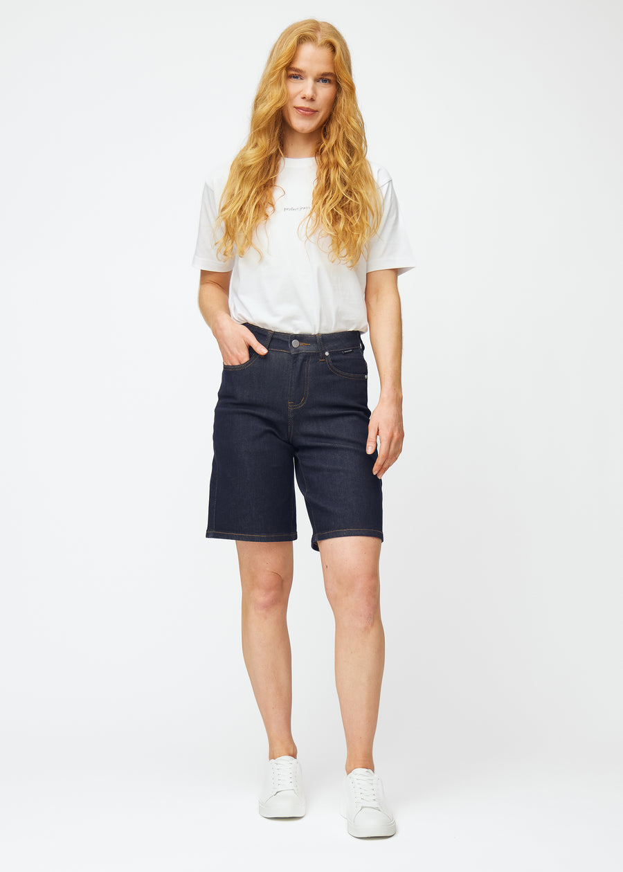 Ganzkörperbild eines Models in tief dunkelblauen Denim-Shorts für Damen in der Farbe Midnights mit Loose-Passform.