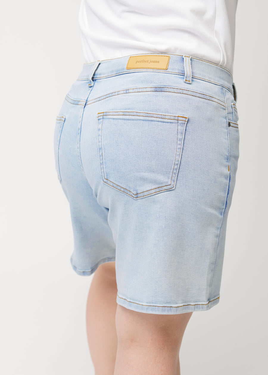 Nahaufnahme von hinten eines weiblichen Models in hellblauen Waves Denim-Shorts.