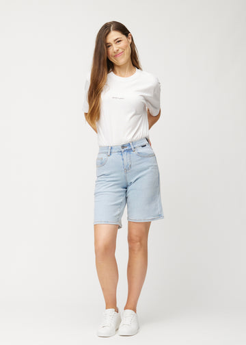 Ganzkörperaufnahme eines Models in hellblauen Waves Denim-Shorts für Damen mit mittelhohem Bund (Mid Rise) und Loose Fit.