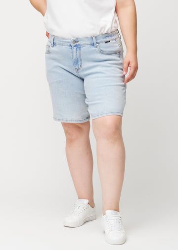 Vorderansicht eines weiblichen Models in hellblauen Waves Denim-Shorts mit mittelhohem Bund (Mid Rise) und Loose Fit.