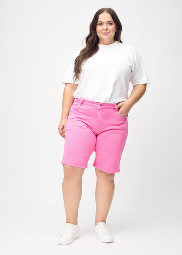 Ganzkörperbild eines Plus-Size-Models in hellrosa regular middle shorts.