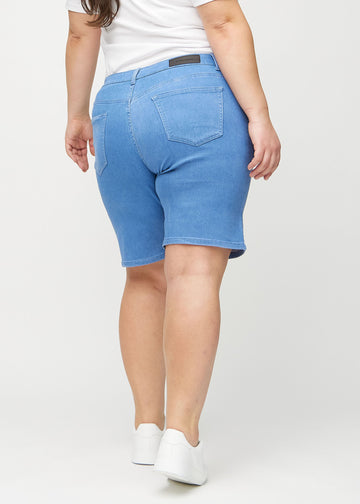 Blaue regular Middle Shorts von hinten an einem Plus-Size-Model gezeigt, damit man das gesamte Produkt sehen kann.