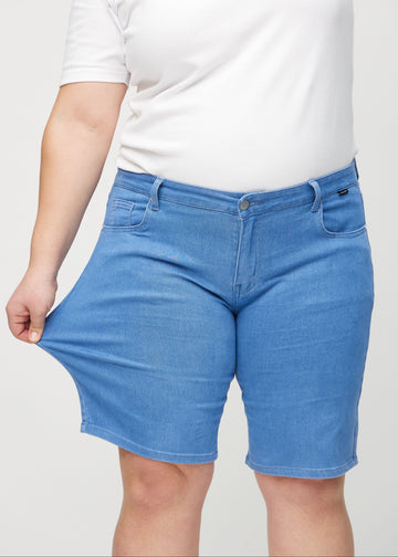 Das Plus-Size-Model zieht die Shorts am Oberschenkel auseinander, um den Stretch zu zeigen.