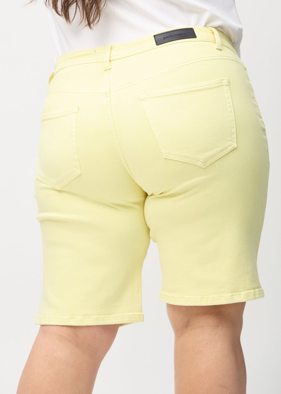 Hellgelbe regular Middle Shorts von hinten aus der Nähe an einem Plus-Size-Model gesehen, um Details zu zeigen.