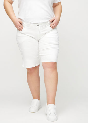 Weiße regular Middle Shorts, Modellname Marguerites, die am Bein gerade nach unten verlaufen und knapp über dem Knie enden, an einem Plus-Size-Model von vorne gesehen.