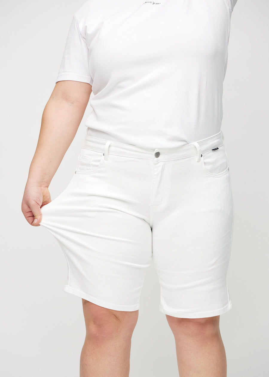 Das Plus-Size-Model zieht die Shorts am Oberschenkel auseinander, um den Stretch zu zeigen.