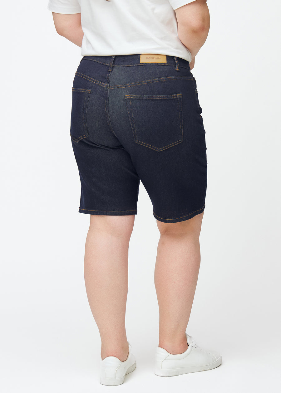 Tief dunkelblaue Denim-Shorts für Damen in der Farbe Midnights von hinten auf einem Plus-Size-Model gesehen.