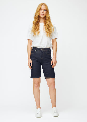 Ganzkörperbild eines Models in tief dunkelblauen Denim-Shorts für Damen in der Farbe Midnights mit Regular-Passform.