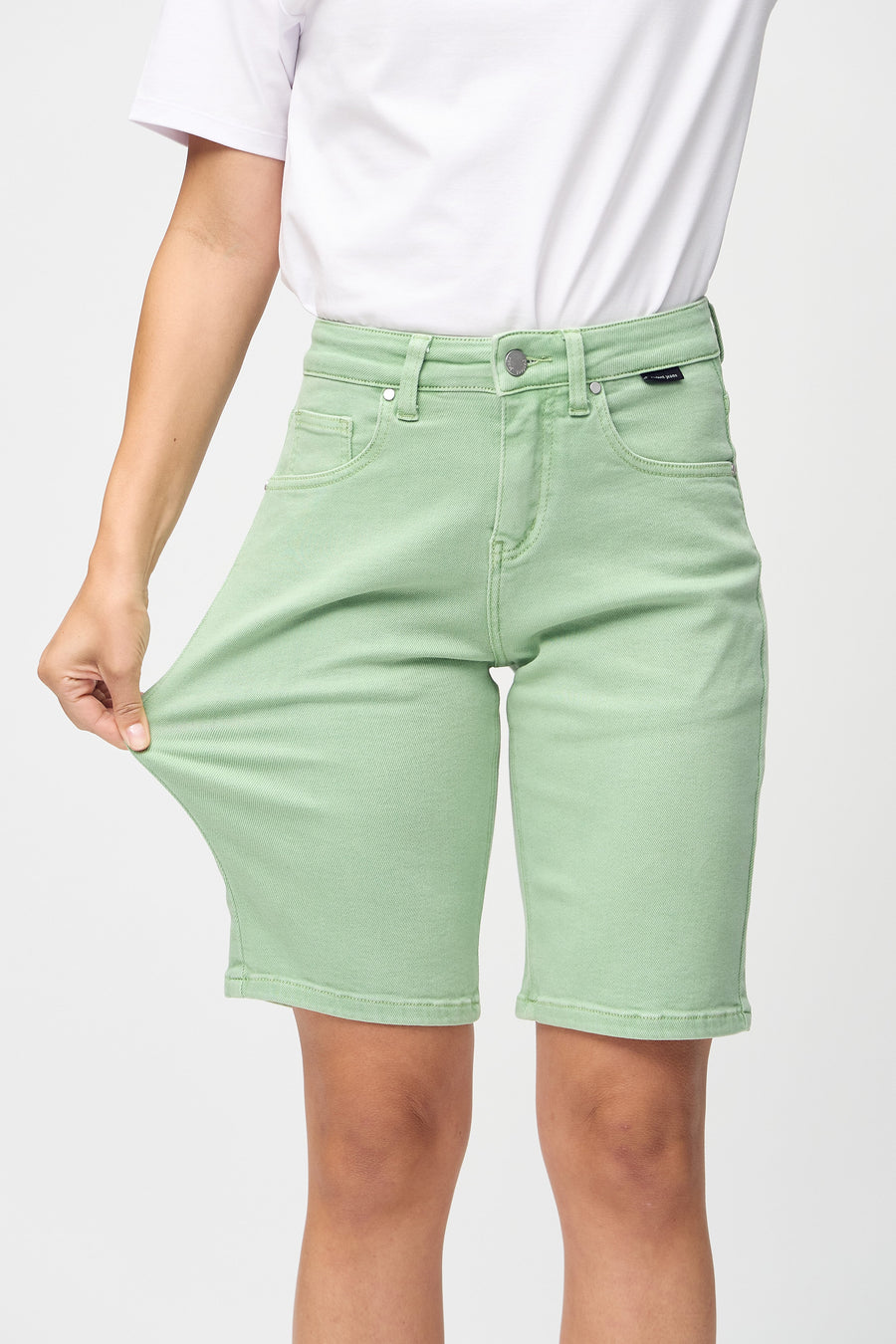 Das Model zieht die Shorts am Oberschenkel auseinander, um den Stretch zu zeigen.