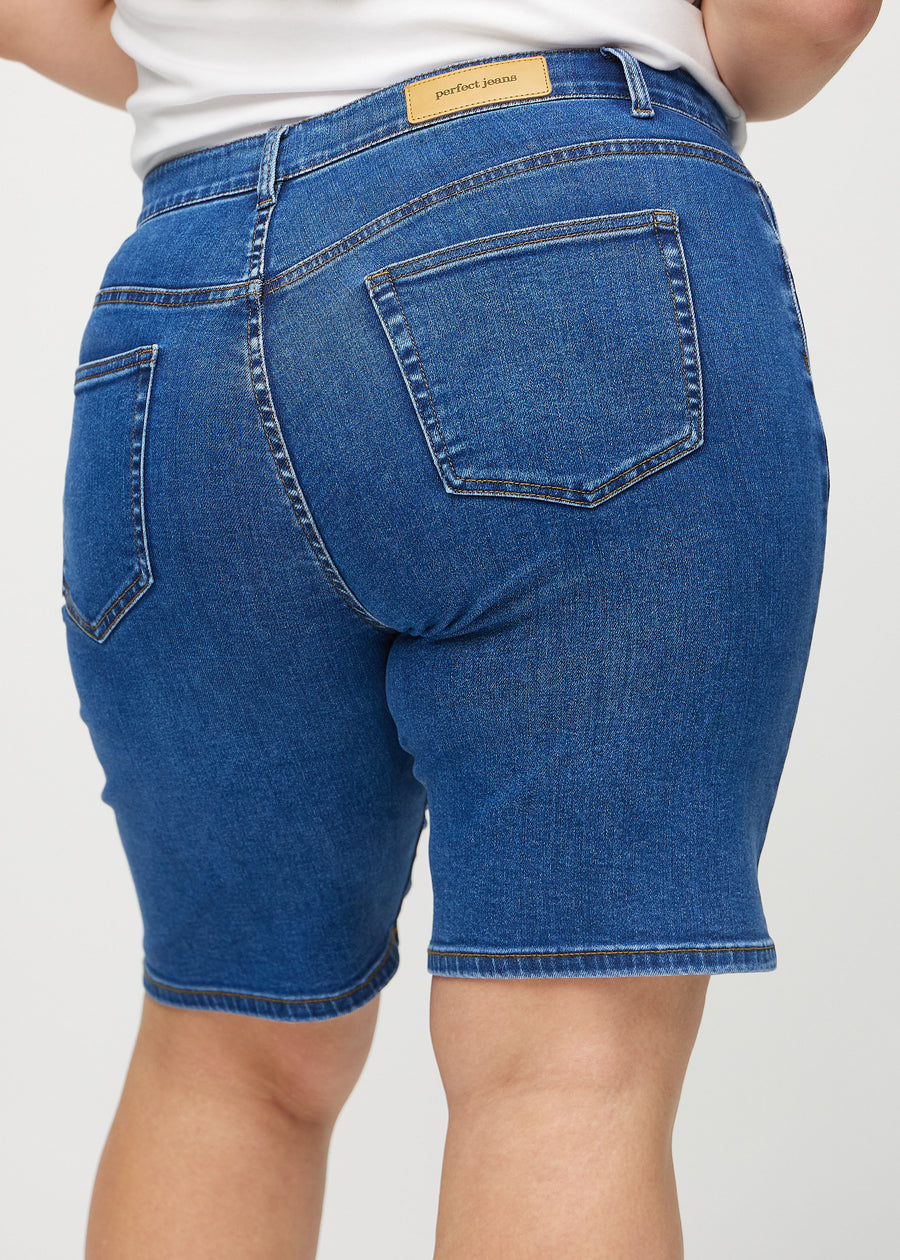 Dunkle Denim-regular middle shorts von hinten in Nahaufnahme an einem Plus-Size-Model, um Details zu zeigen.