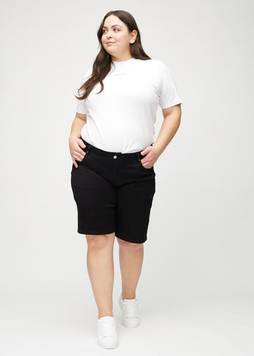 Ganzkörperbild eines Plus-Size-Models in schwarzen regular Middle Shorts.