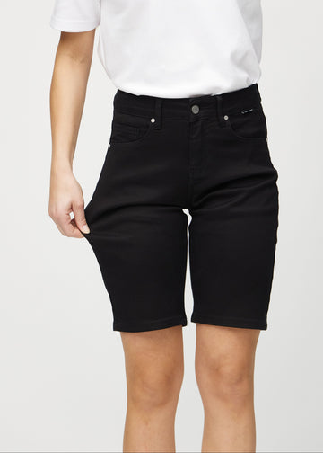 Das Model zieht die Shorts am Oberschenkel auseinander, um den Stretch zu zeigen.