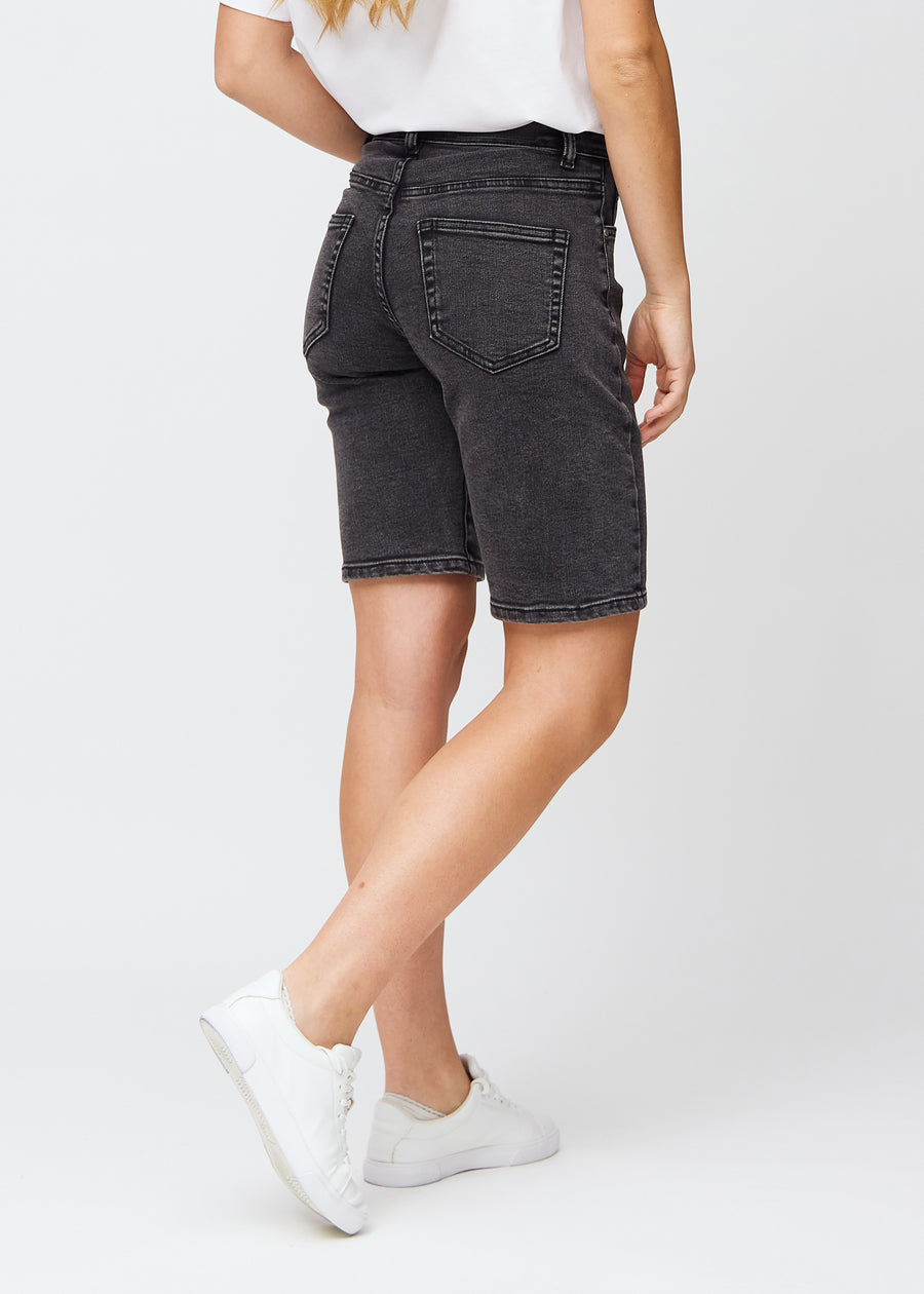 Frau in knielangen dunkelgrauen Denim-Shorts, von hinten gesehen