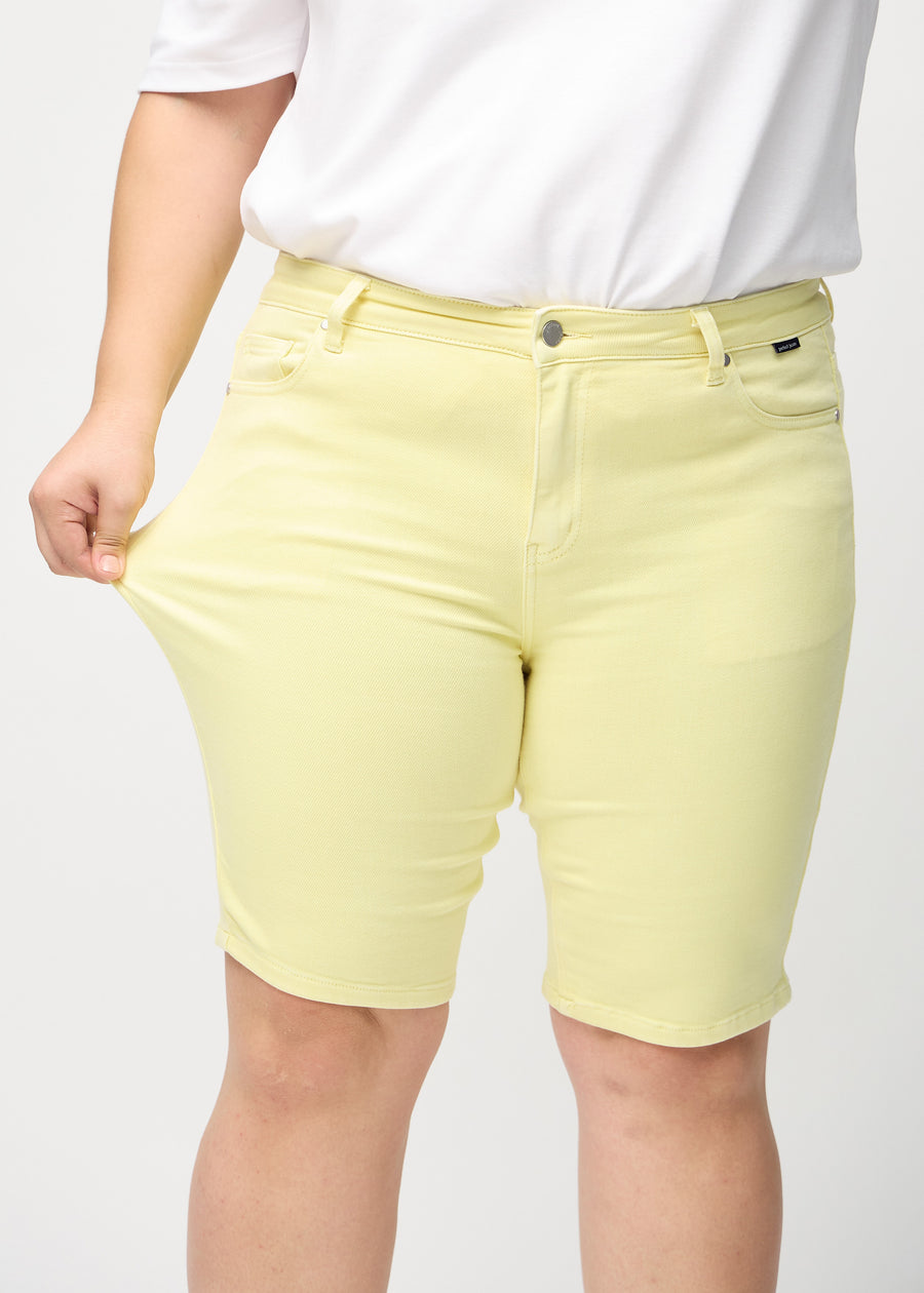 Das Plus-Size-Model zieht die Shorts am Oberschenkel auseinander, um den Stretch zu zeigen.