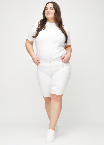 Ganzkörperbild eines Plus-Size-Models in weißen skinny Middle Shorts.