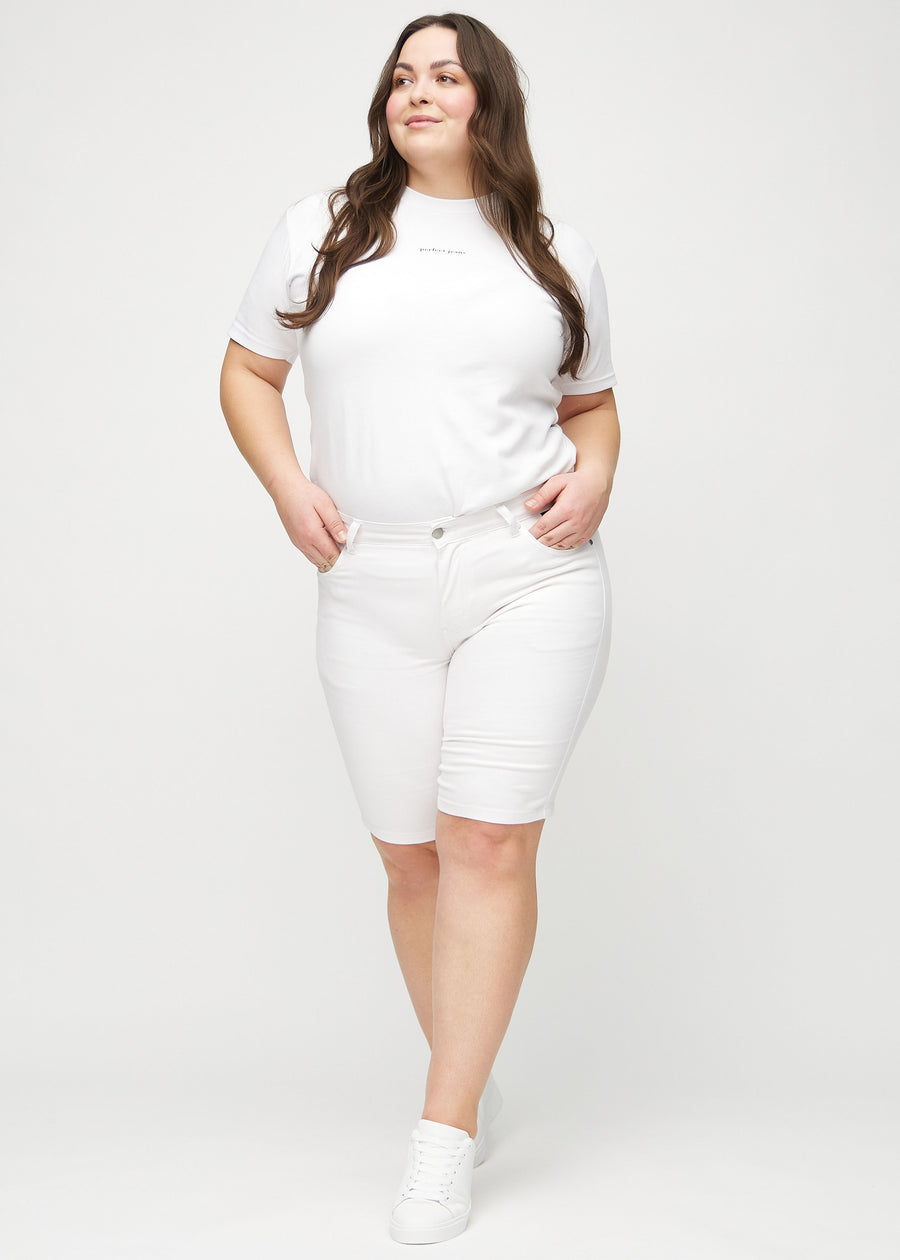 Ganzkörperbild eines Plus-Size-Models in weißen skinny Middle Shorts.