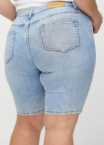 Helle Denim-skinny Middle Shorts von hinten in Nahaufnahme an einem Plus-Size-Model, um Details zu zeigen.
