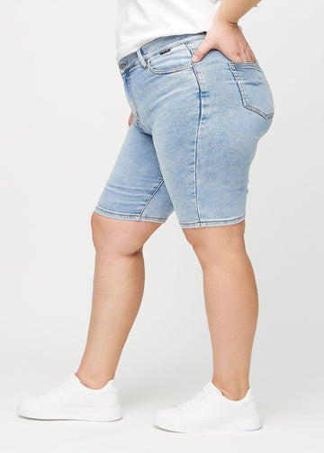 Helle Denim-skinny Middle Shorts an einem Plus-Size-Model von der Seite gesehen.