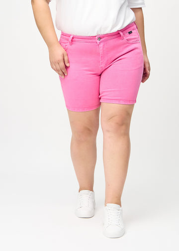 Hellrosa skinny Short Shorts, Modellname Flamingos, die eng anliegen und mittig am Oberschenkel enden, an einem Plus-Size-Model von vorne gesehen.
