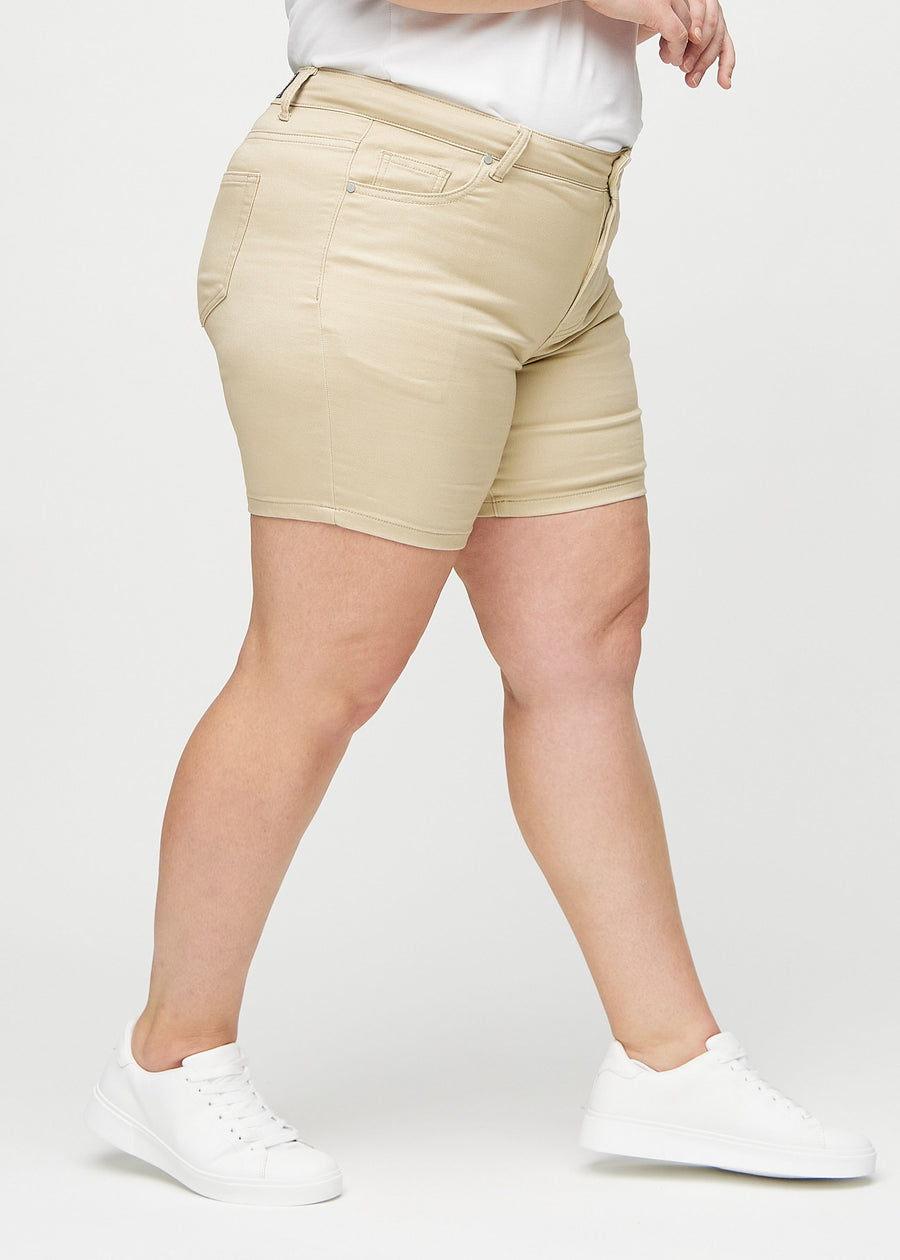 Beige skinny Short Shorts seitlich an einem Plus-Size-Model gezeigt.