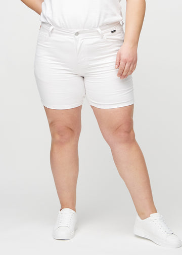 Weiße skinny Short Shorts, Modellname Marguerites, die eng anliegen und bis zur Mitte des Oberschenkels reichen, an einem Plus-Size-Model von vorne gesehen.