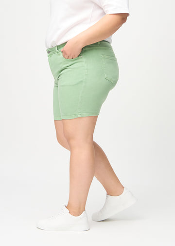 Hellgrüne skinny Short Shorts, von der Seite an einem Plus-Size-Model gesehen.