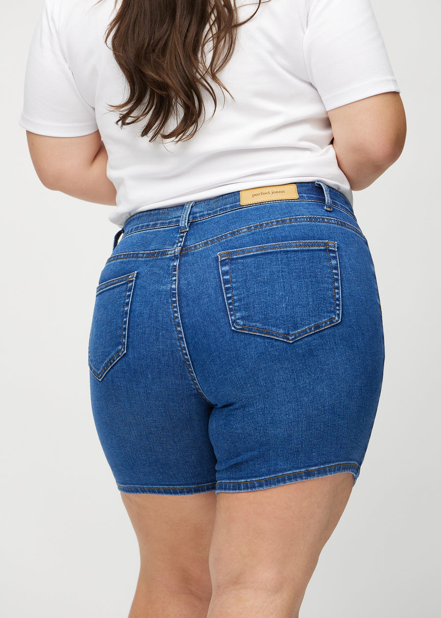 Dunkle Denim-skinny Short Shorts von hinten aus der Nähe an einem Plus-Size-Model gesehen, um Details zu zeigen.